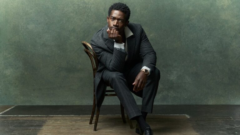 Tommy Hilfiger tweed coat and Harlem pants; Zegna Oasi cashmere polo; Gianvito Rossi shoes; IWC Portugieser Hand-Wound Tourbillon Day and Night in black with 18-karat Armor Gold® case.