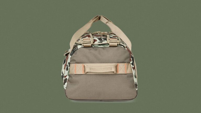 Filson All-Weather 50L Duffle Bag in Shrub Camo against a dark green background