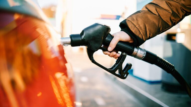 Red car is filled at gas station