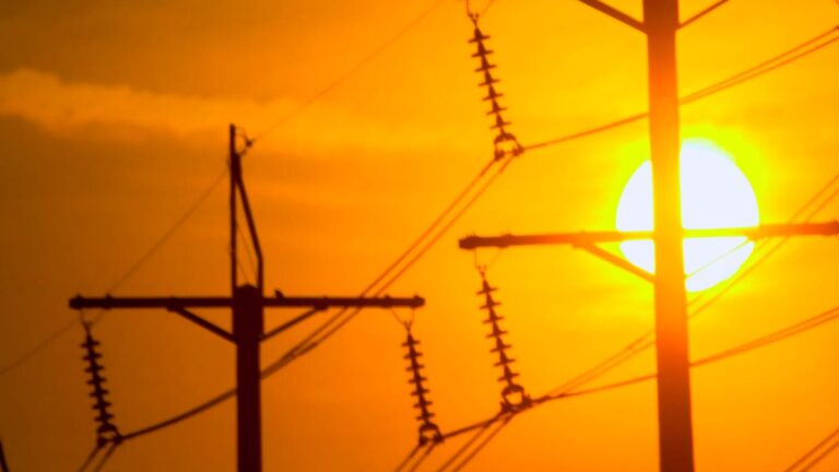 A bright sun bearing down on power lines.