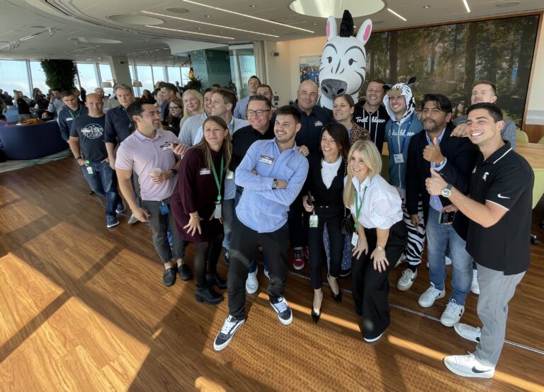 A group of AE Excellence Academy grads gather with Ziggy, the Salesblazer mascot