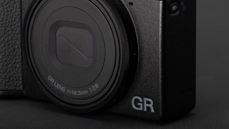 Close-up of a black camera with a textured body, featuring a GR lens with specifications