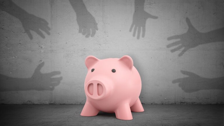 Shadowy hands on a gray background reach for a piggy bank in the middle.