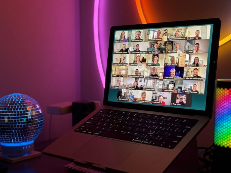 A Zoom grid view of Buffer teammates during the first Creator Café workshop, displayed on a laptop screen with colorful ambient lighting in the background.
