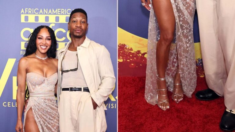 Meagan Good wears strappy silver metallic wrap stiletto sandals alongside Jonathan Majors at the 7th Annual AAFCA Awards on Saturday.