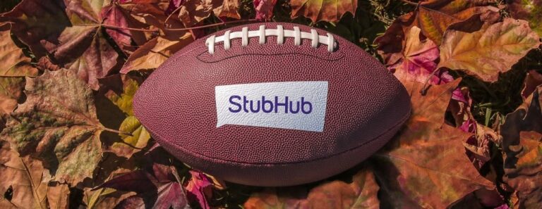 a football with the StubHub logo, in a pile of leaves