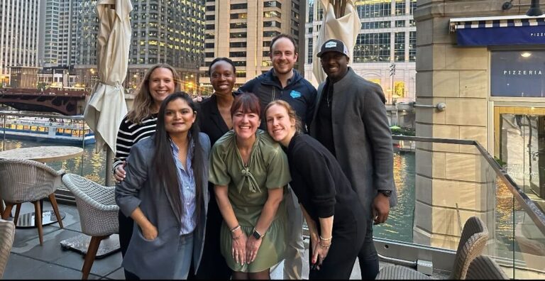 Sam poses with his team in front of the Chicago skyline