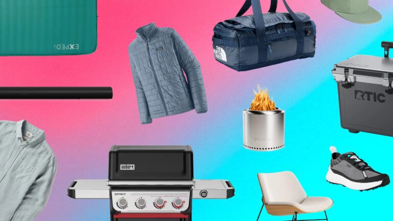 A collection of outdoor and casual items including a green sleeping pad, a light blue puffer jacket, a navy blue duffel bag, a green baseball cap, a gray cooler with