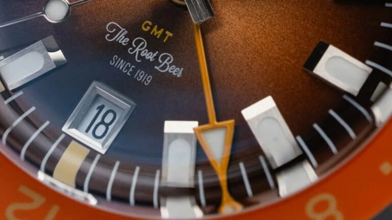 Close-up of a watch face with a brown gradient dial, featuring the text
