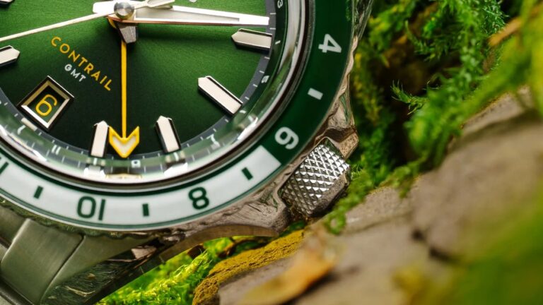 Close-up of a green Nodus Contrail GMT watch face showing the date