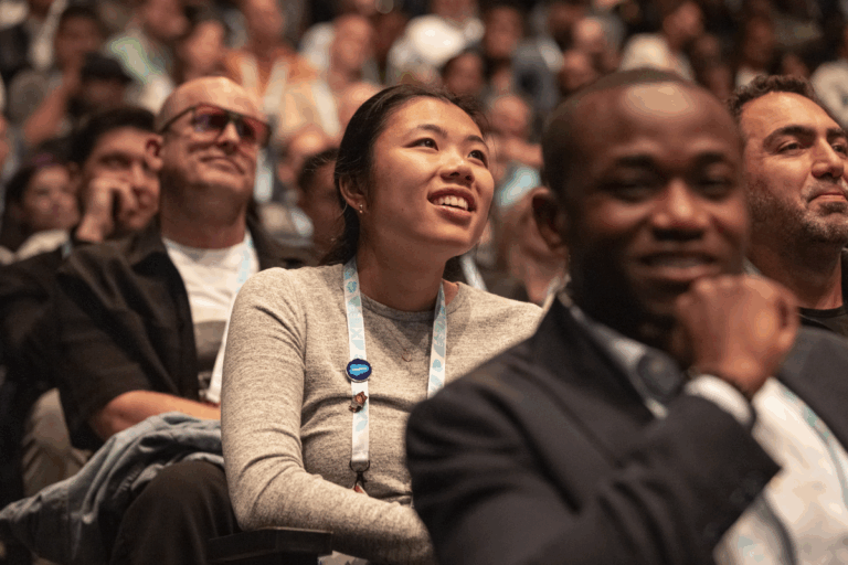 5 Reasons to Attend the Dreamforce IT Keynote People smiling in the audience of a presentation at Dreamforce.