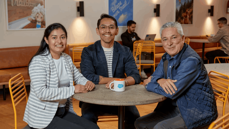 Three Salesforce employees spending time together in a cafeteria.