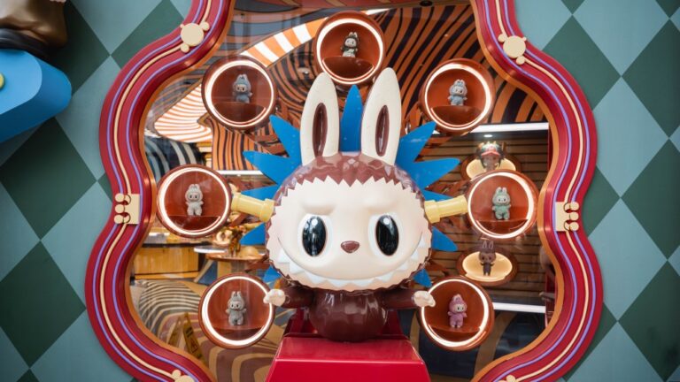 A Labubu surrounded by lit shelves holding miniature versions of the toy at Pop Mart's mega global landmark store at Iconsiam, Bangkok.