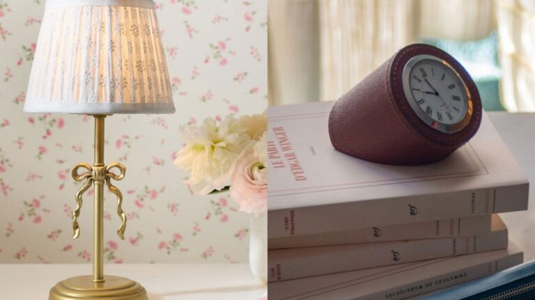 ornate, vintage-inspired lamp with a bow at center standing on table; leather table clock resting on a pile of books