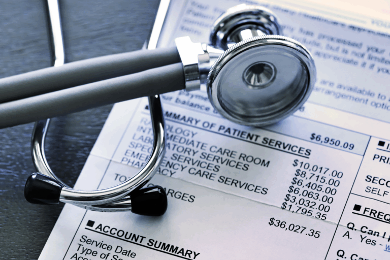 A closeup of a medical bill with a stethoscope resting on top of it.