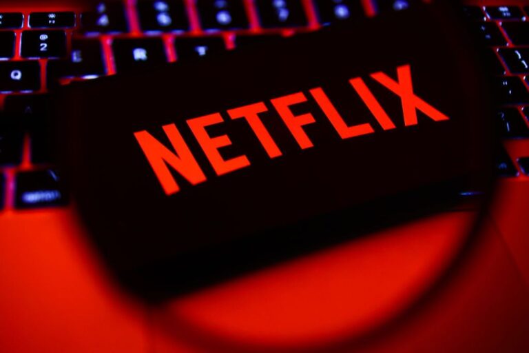 What Netflix Stock’s 10-for-1 Split Means for Investors Netflix logo on smartphone sitting on computer keyboard
