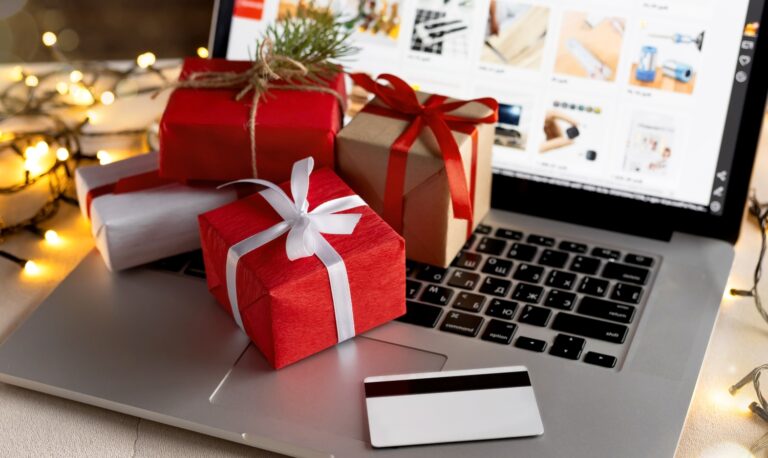 How to Build Holiday Traffic to Your Online Store This Season Wrapped presents on top of a laptop keyboard with a credit card next to them.